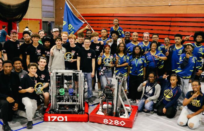  students posing with a robot